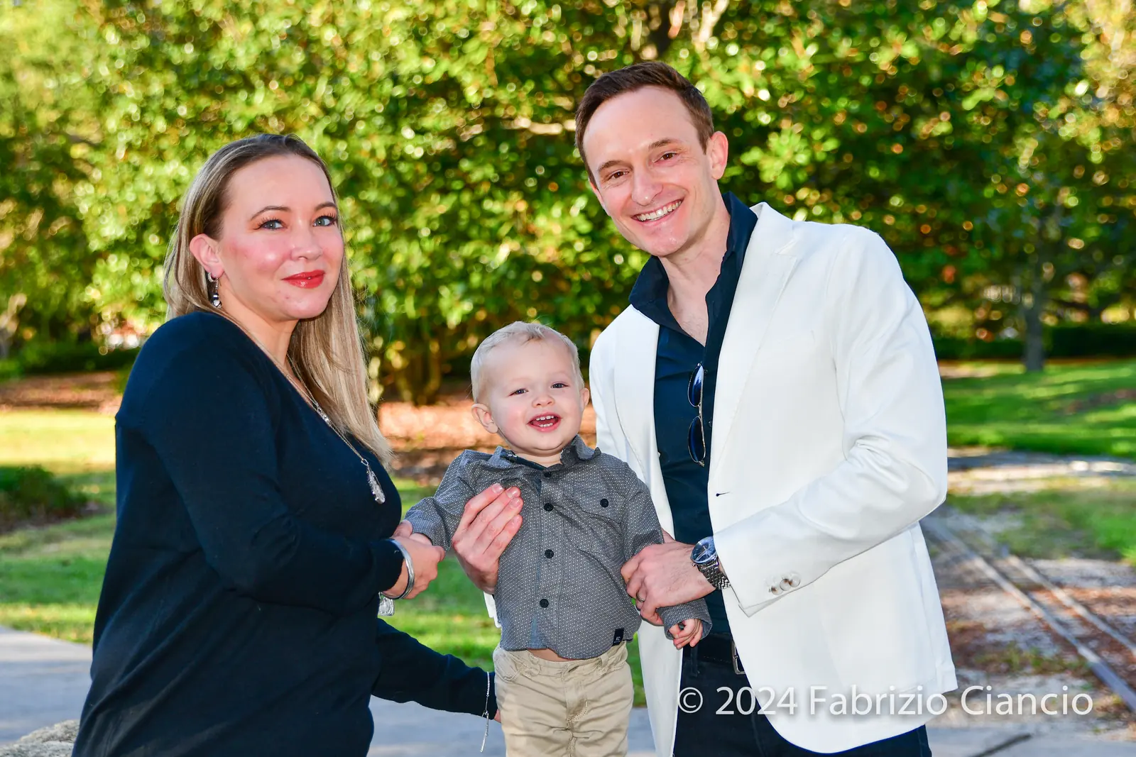 Parents with their baby in a sunlit park