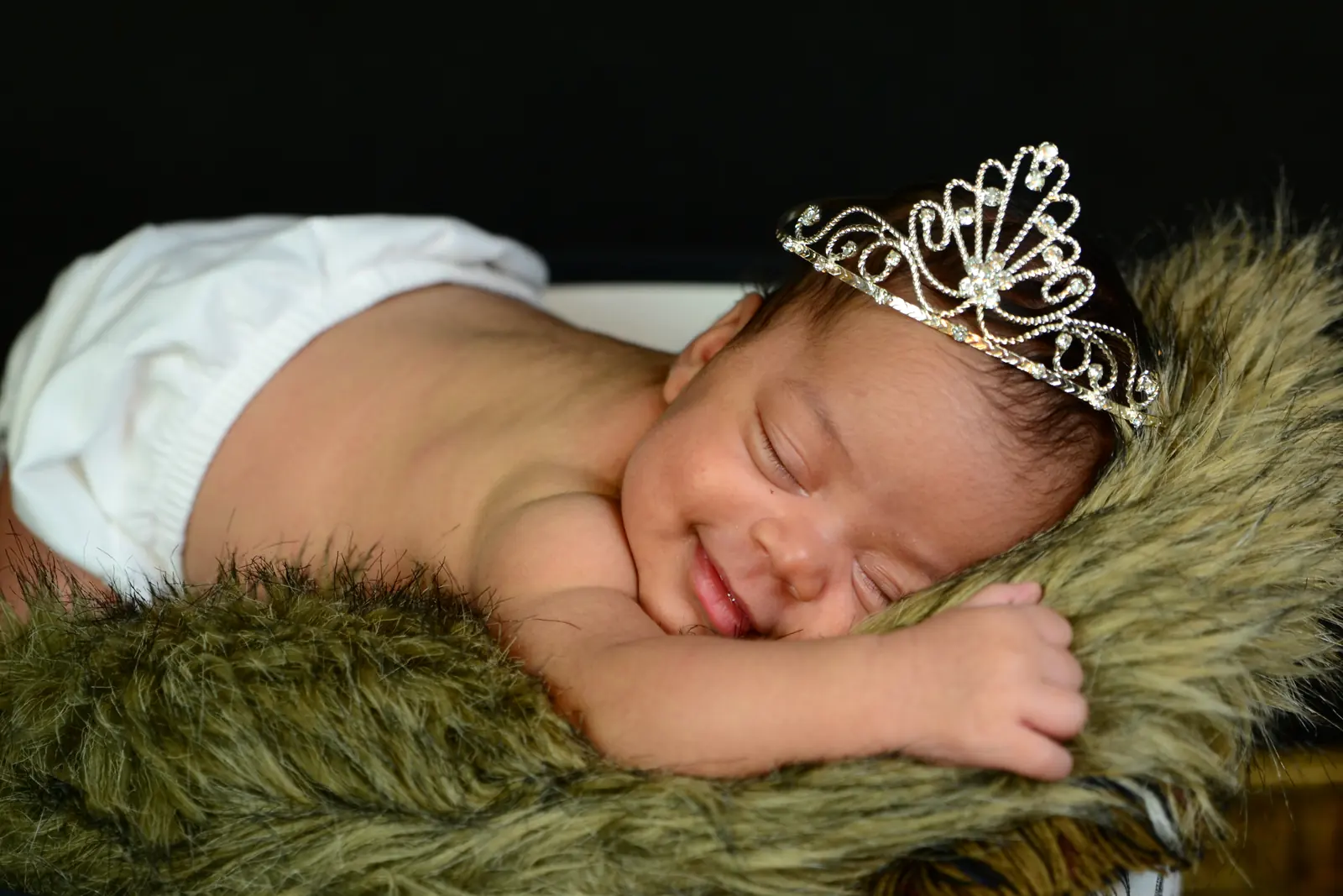 Sleeping newborn wearing a small decorative crown