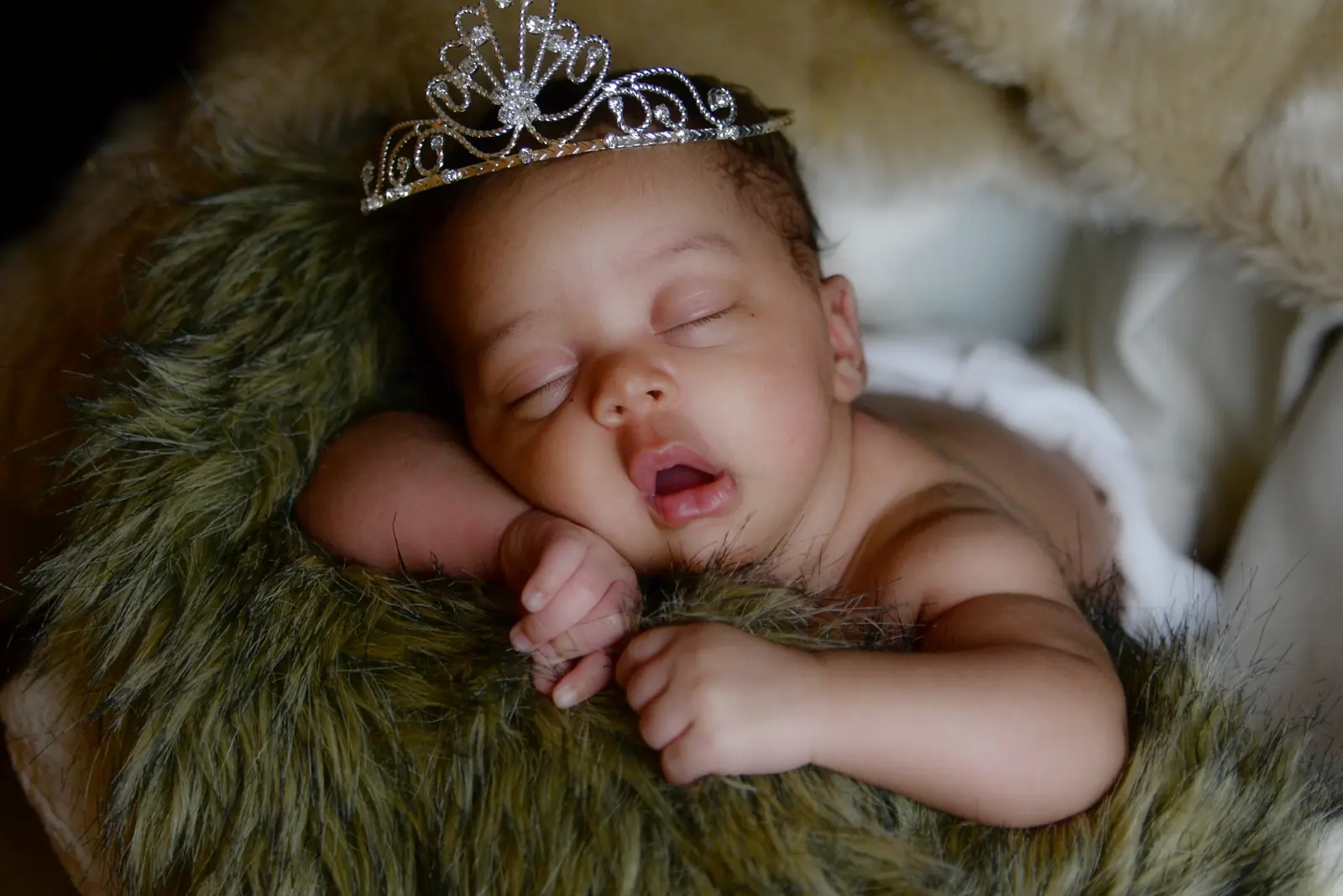 Newborn resting on a soft textured blanket
